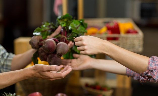 woman-buying-beetroot-from-vendor-in-the-grocery-store_107420-872401